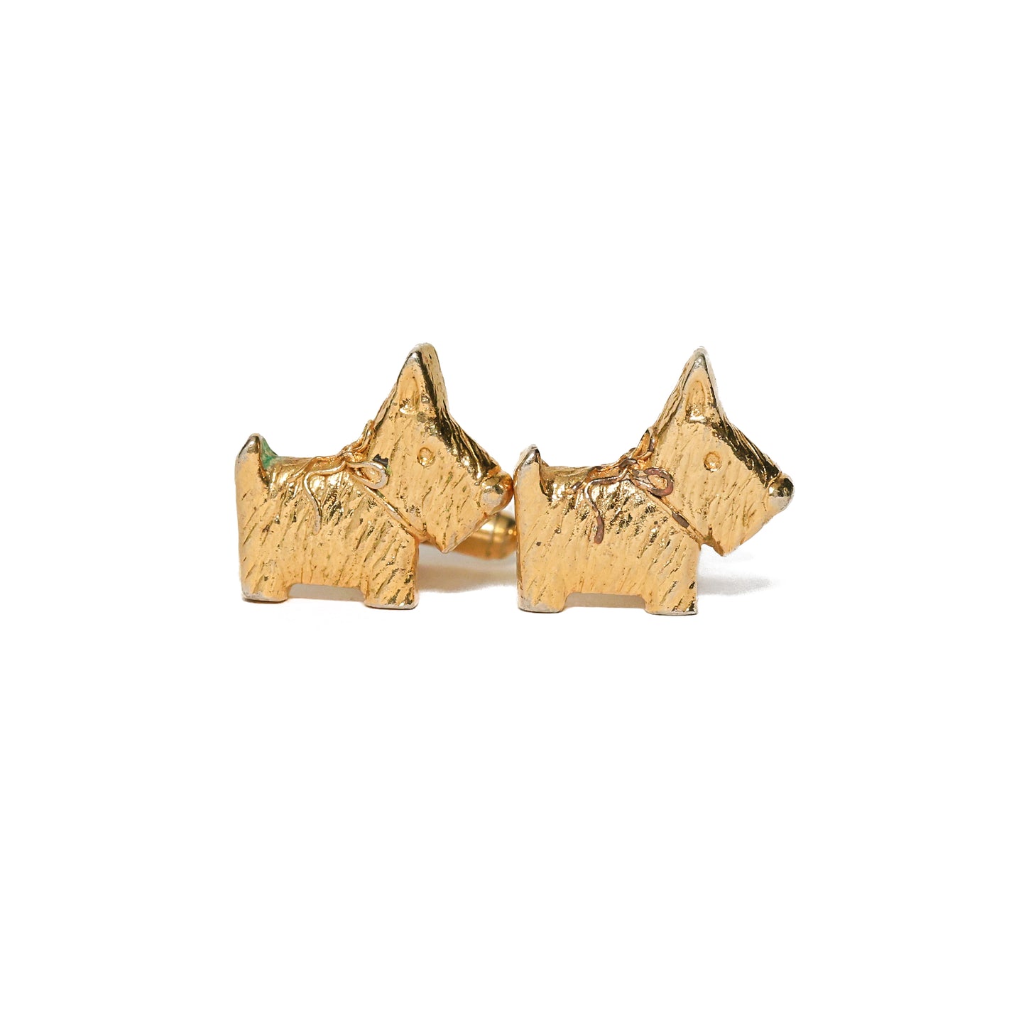 Sjarmerende vintage mansjettknapper fra 70-tallet med motiv av den karakteristiske scottish terrier. Den teksturerte overflaten fanger hundens ruslete pels på fint vis, og den varme gulltonen gir et elegant uttrykk. En personlig detalj til skjorten for hundevennen eller mannen som verdsetter motiver med karakter.