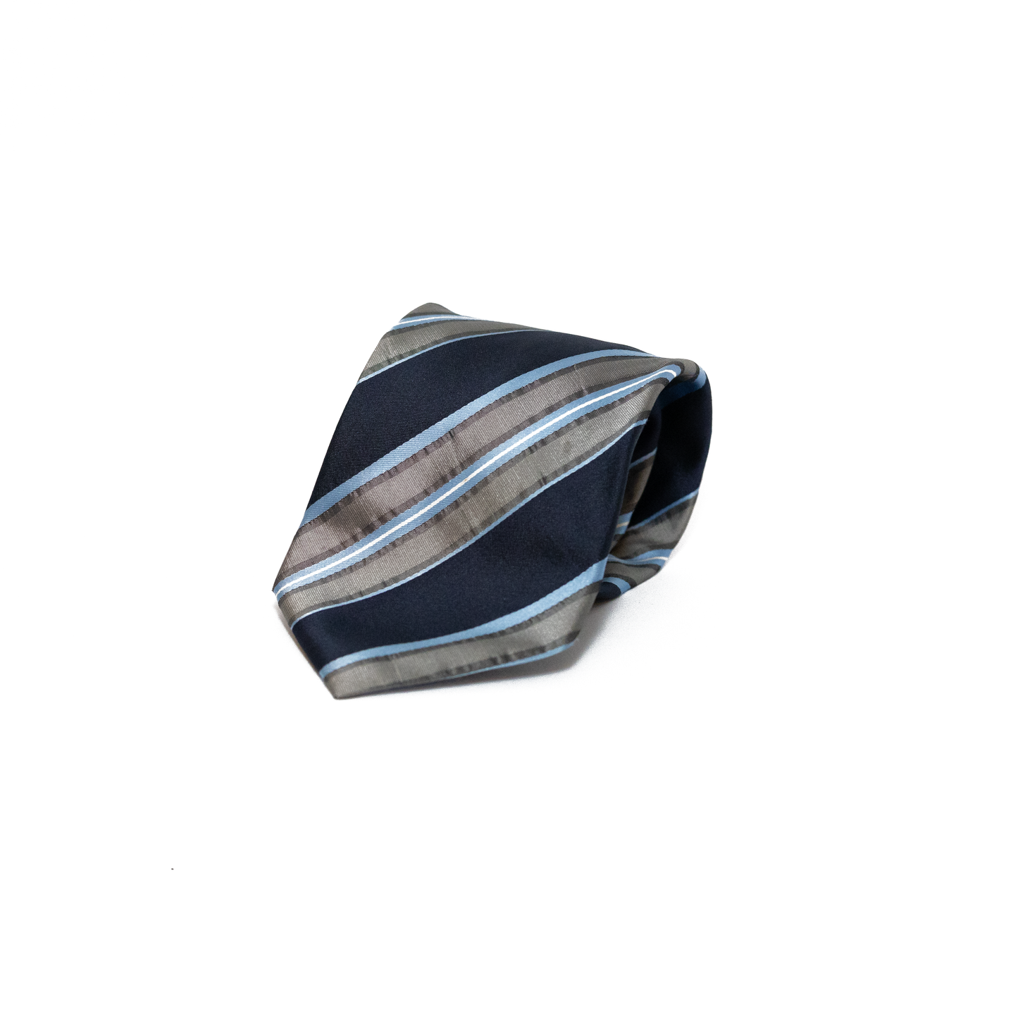 Vintage silkeslips fra Valentino med diagonale striper i marineblå, lyseblå og varmgrå over hele lengden. Den glatte silken fanger lyset og gir stripene et fint glansspill, og den klassiske regimental-stilen gir slipset et stramt og raffinert uttrykk.
