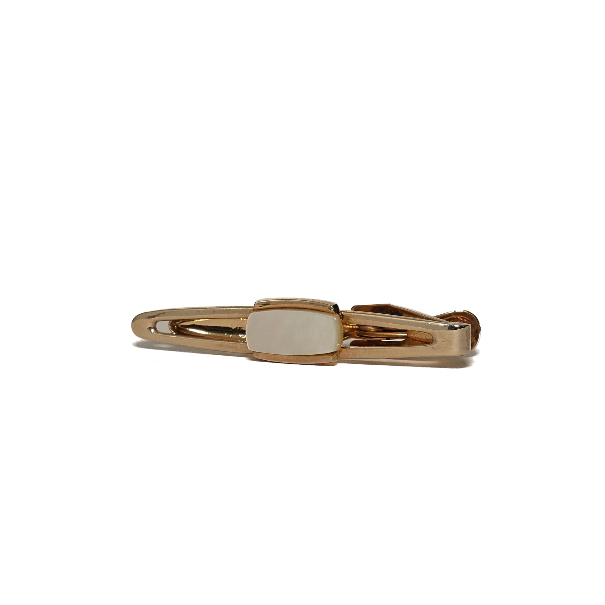 Vintage slipsnål fra 60-tallet i avlang form og gulltone, med en åpen, oval ramme som omkranser et lite midtfelt i skimrende perlemor. Den luftige konstruksjonen gir slipsnålen et lett og raffinert preg, og perlemoret skifter fint i lyset gjennom dagen. Et elegant valg for mannen som setter pris på rene linjer og diskrete materialer.