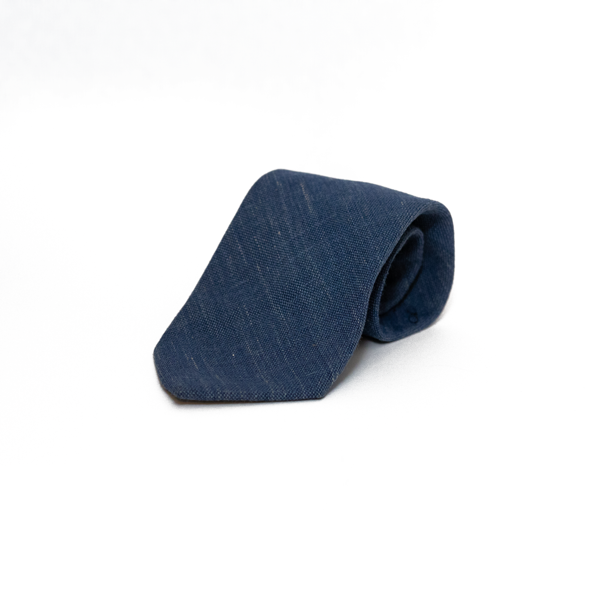 Mørkeblått vintage slips fra Brian Lynch, vevd i en grovere struktur som gir slipset en matt overflate og en naturlig variasjon i fargen. Den teksturerte vevingen gir slipset karakter og dybde, samtidig som det holder seg innenfor et klassisk og dempet uttrykk.